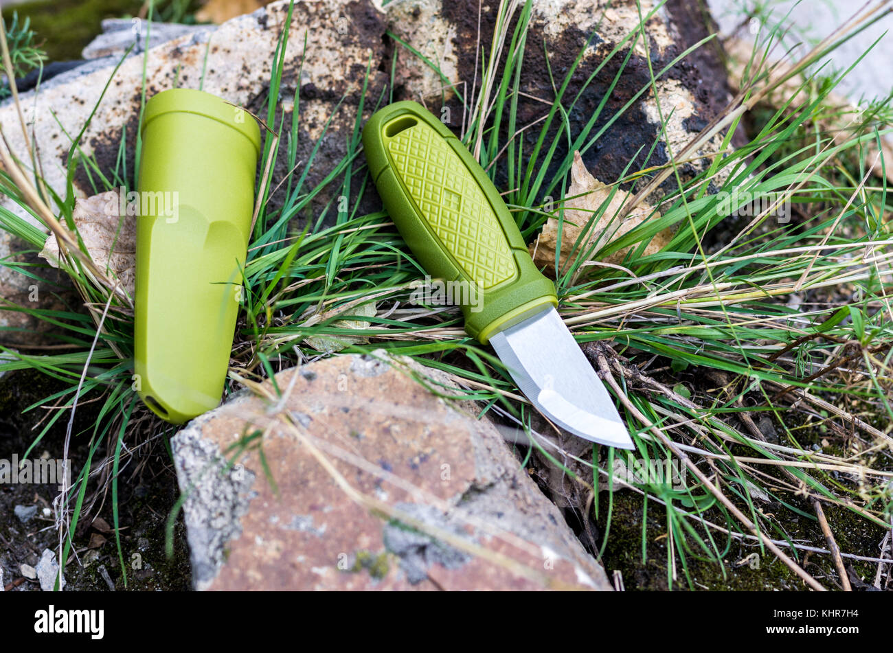 Un couteau avec une poignée verte. Couteau et gaine plastique. Photo d'extérieur. Banque D'Images