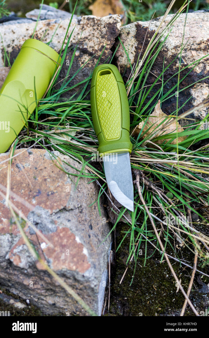 Un couteau avec une poignée verte. Couteau et gaine plastique. Tir vertical. Photo d'extérieur. Banque D'Images