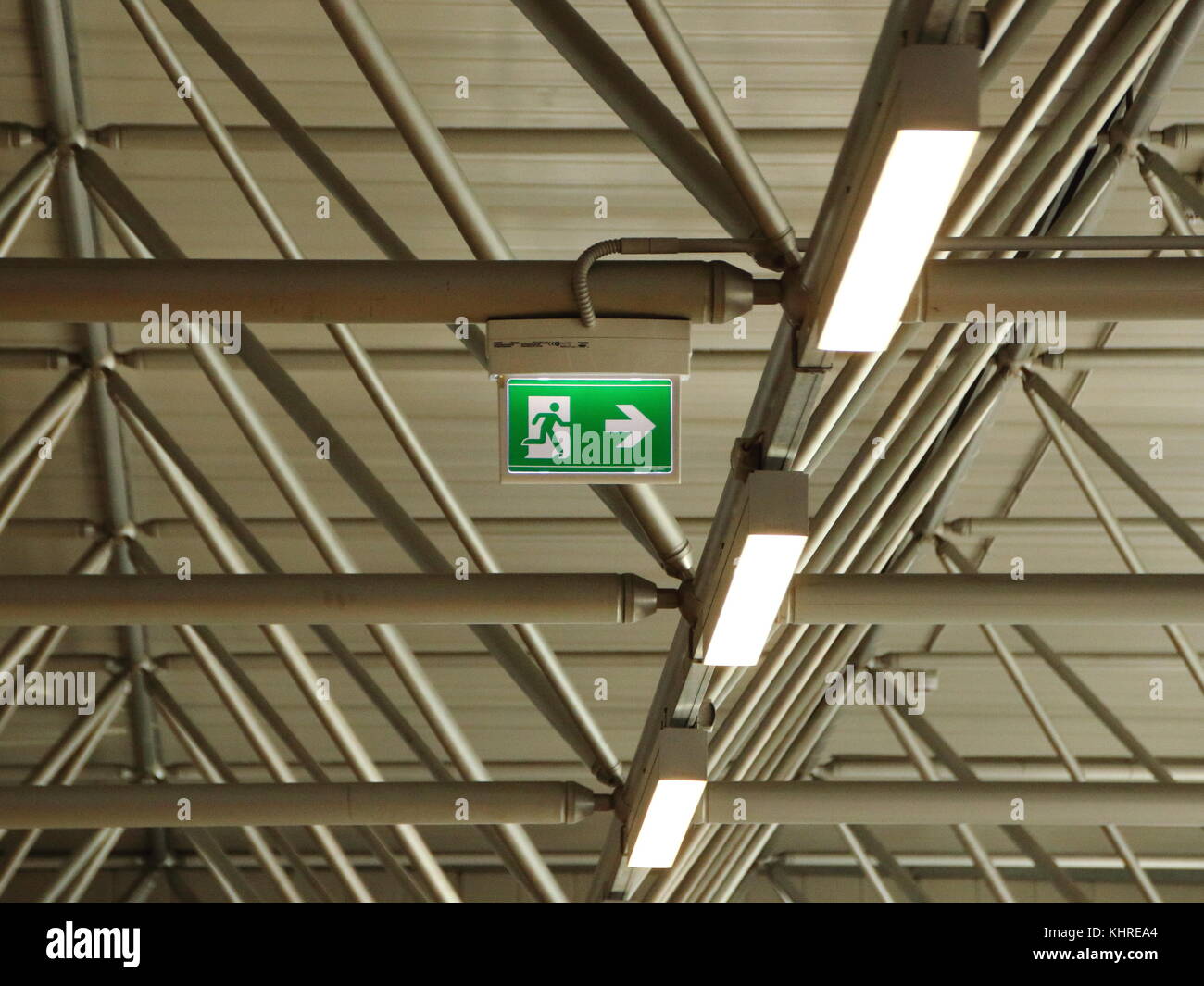 Enseigne de sortie d'urgence vert sous le toit avec lampes Banque D'Images