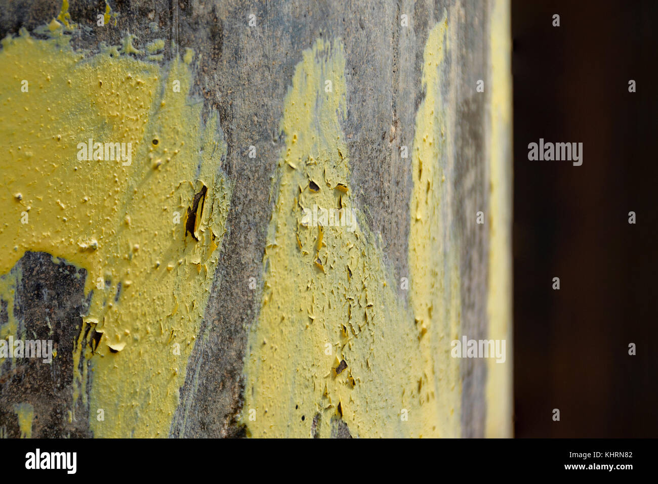 La texture des fissures et peeling peinture jaune sur poteau béton Banque D'Images