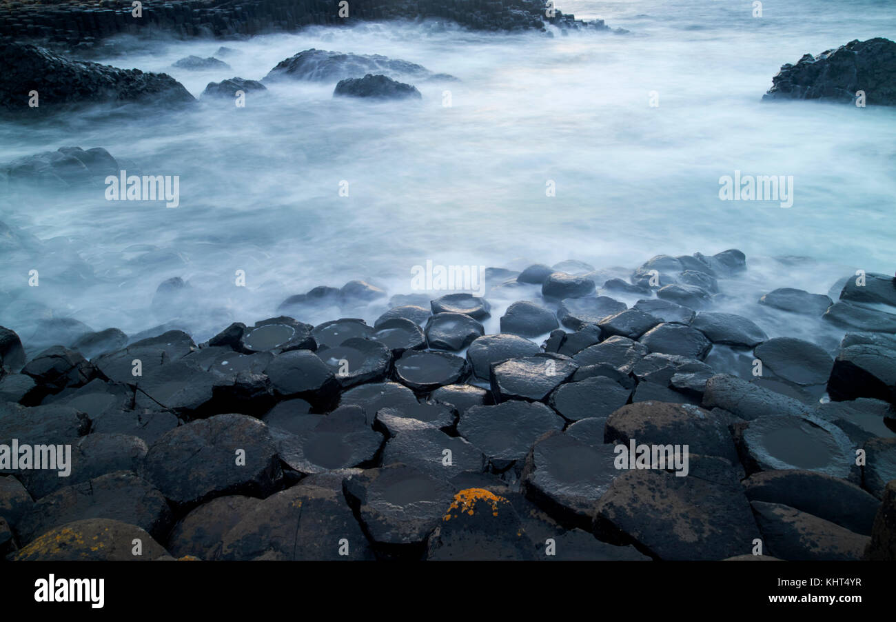 Dans les roches crépuscule du soir avec la mer laiteuse en raison d'une longue exposition à la Chaussée des Géants le comté d'Antrim en Irlande du Nord uk Banque D'Images