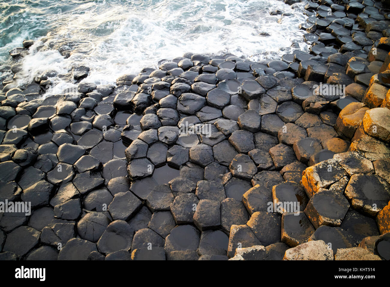 Les roches basaltiques hexagonale noire à la Chaussée des Géants le comté d'Antrim en Irlande du Nord uk Banque D'Images