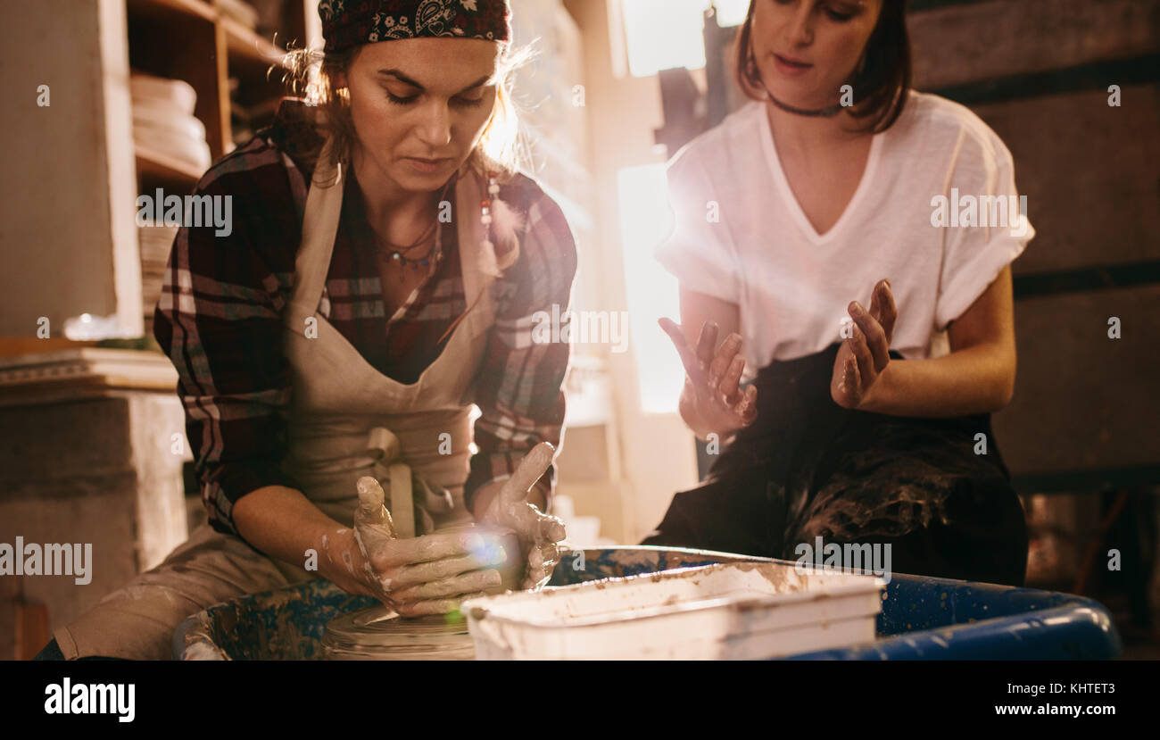 Femme potter enseignement de l'art de faire de pot. Deux femmes dans un atelier de poterie faire des pots d'argile. Banque D'Images