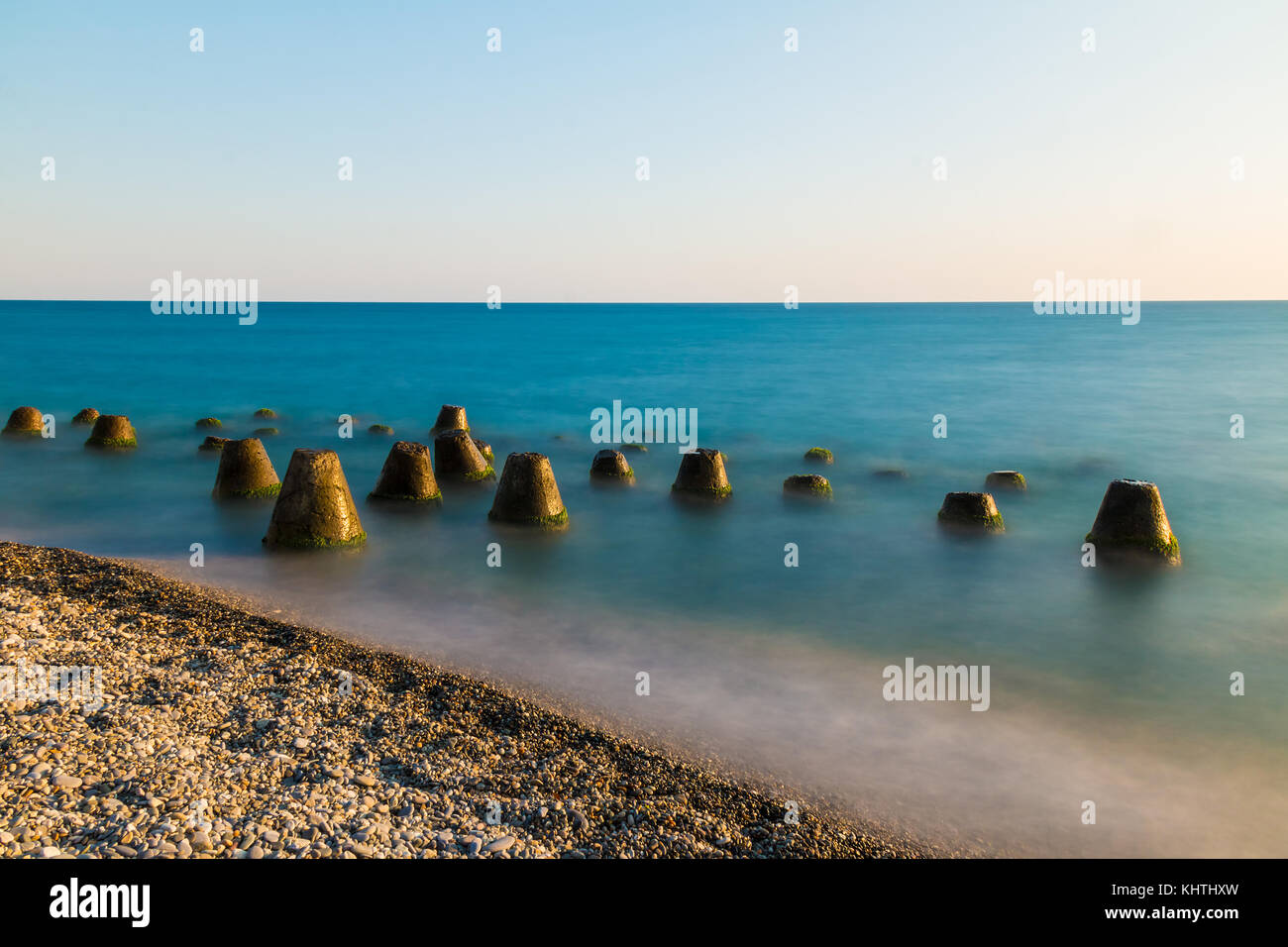 Une longue exposition photo de la conique en béton située dans la mer des rochers près de la plage Banque D'Images