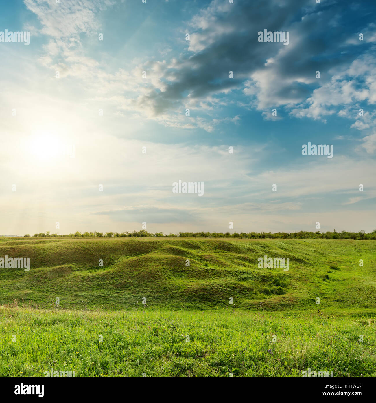 Coucher de soleil dans les nuages spectaculaires sur green meadow Banque D'Images