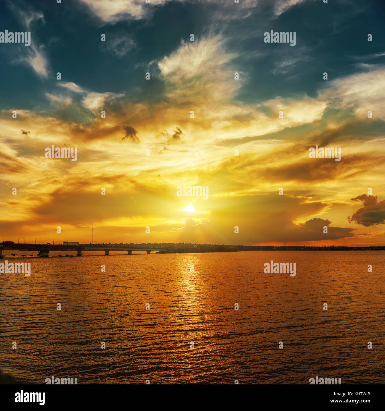 Coucher du soleil orange sur la rivière en ciel dramatique Banque D'Images