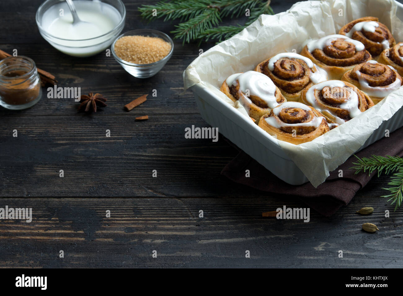 Cannelle ou cinnabon pour Noël. hiver maison traditionnelle pâtisserie pains dessert festif sur fond de bois foncé avec copie espace. Banque D'Images