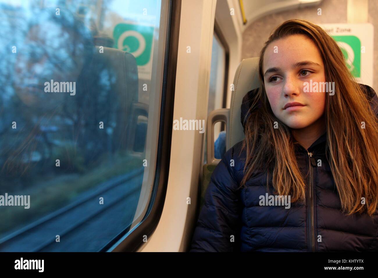 Jeune adolescente en regardant par la fenêtre d'un train qu'elle rachète la maison Banque D'Images
