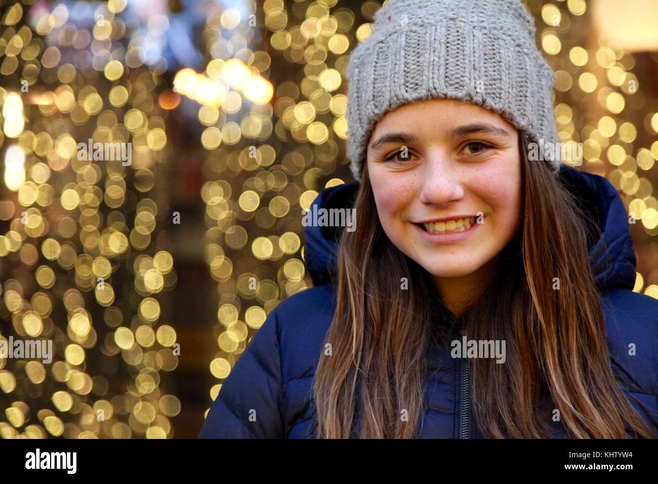 Portrait of a young woman smiling in front of bokeh les lumières de Noël Banque D'Images