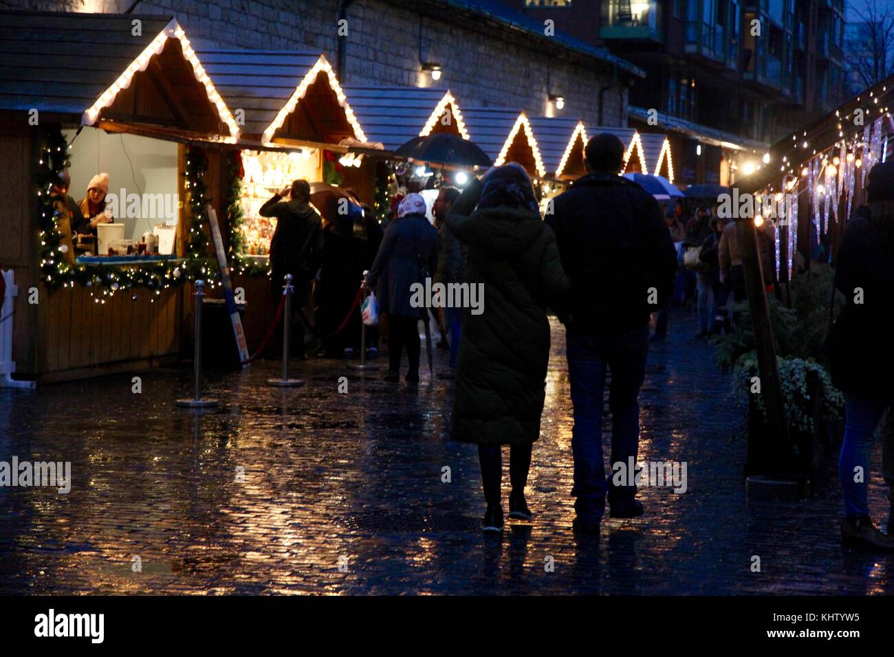 Les gens qui marchent à travers le marché de Noël de Toronto sous la pluie avec la cale lit up at night Banque D'Images