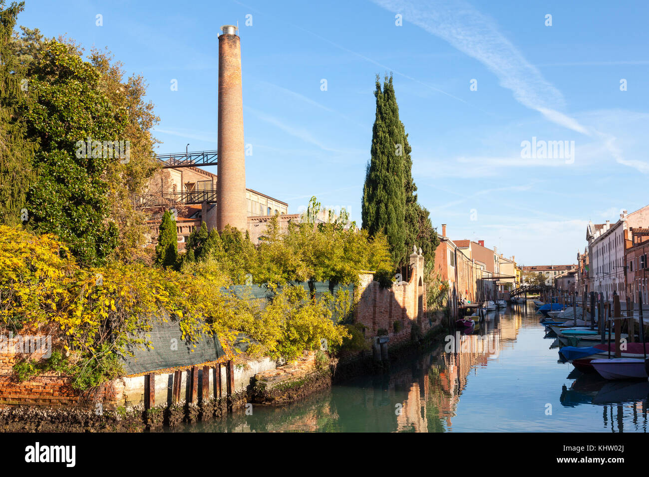 L'architecture industrielle convertie sur le Rio di San Biagio canal dans l''île de Giudecca, à Venise, Italie au coucher du soleil avec des réflexions sur l'eau Banque D'Images