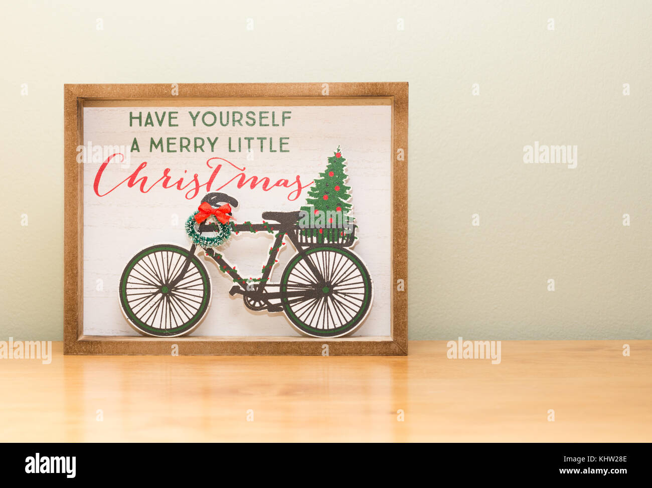 Gros plan d'une décoration de Noël avec un vélo, gerbe à l'arc, arbre de Noël et "have yourself a merry little christmas". Banque D'Images