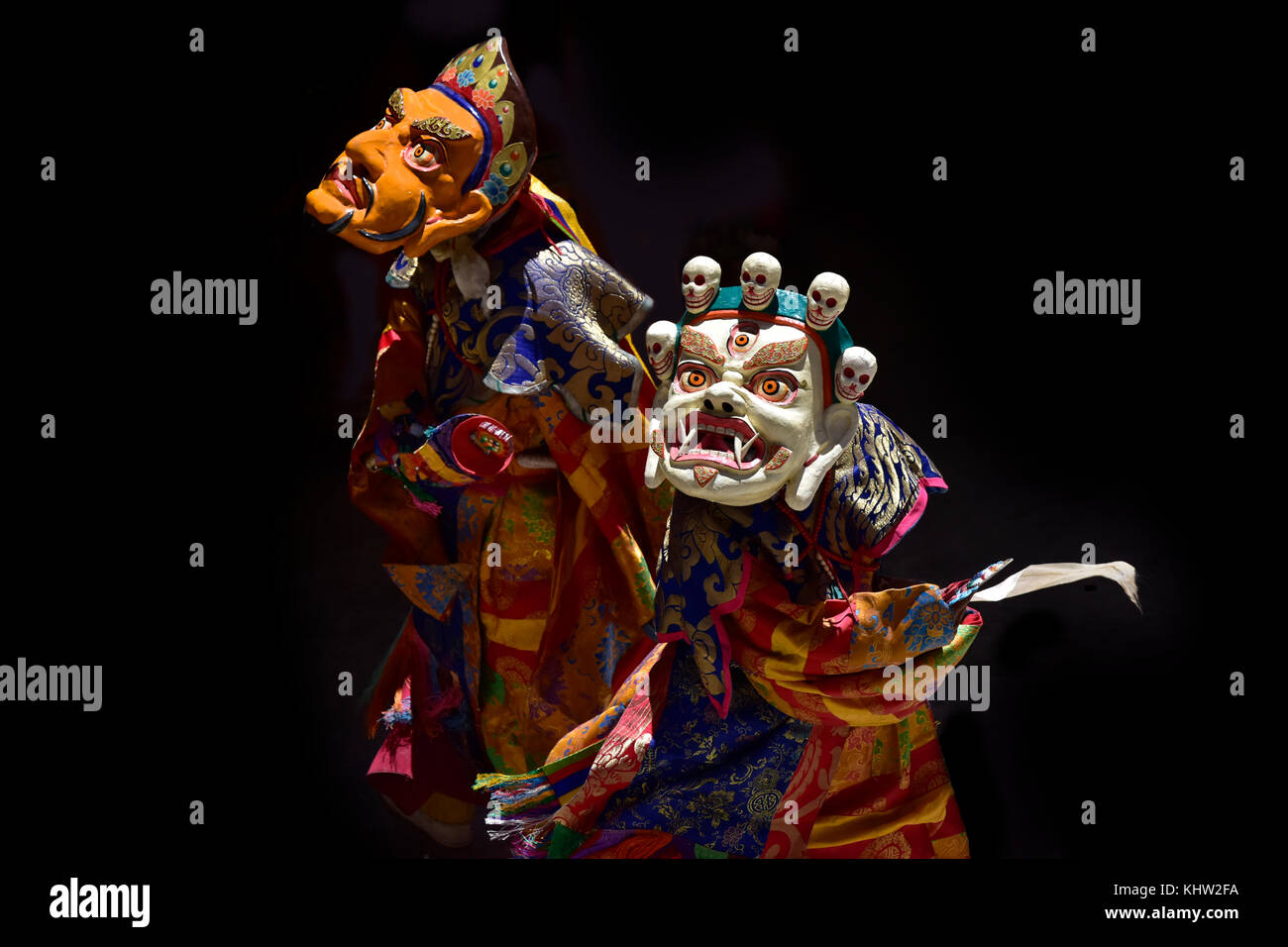 Deux lamas effectuer la danse des masques : en premier plan lama dans le masque blanc de mahakala, en arrière-plan un lama dans le masque jaune de Shambhala. Banque D'Images