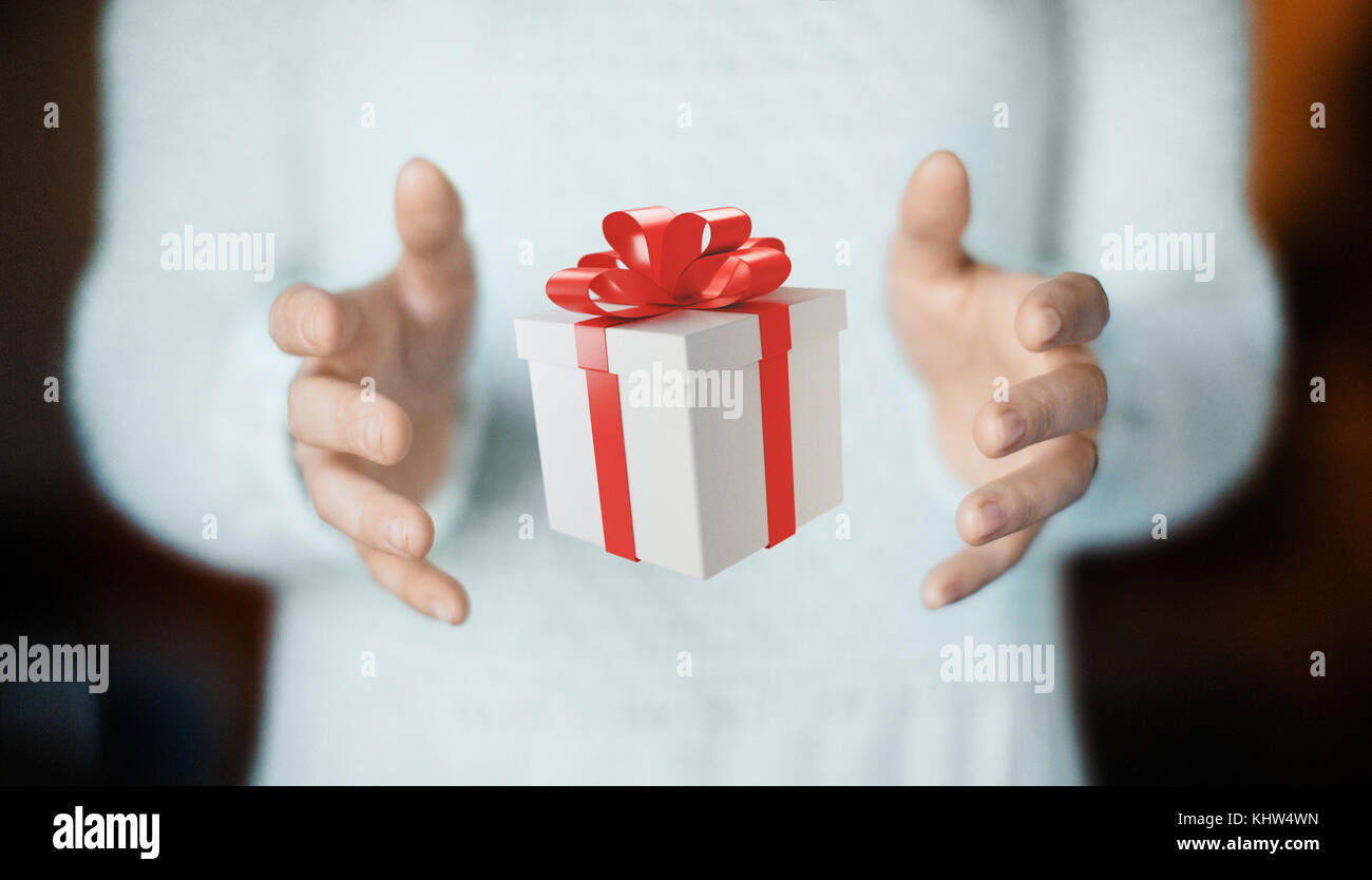Les mains avec boîte-cadeau avec ruban rouge pour Noël Banque D'Images