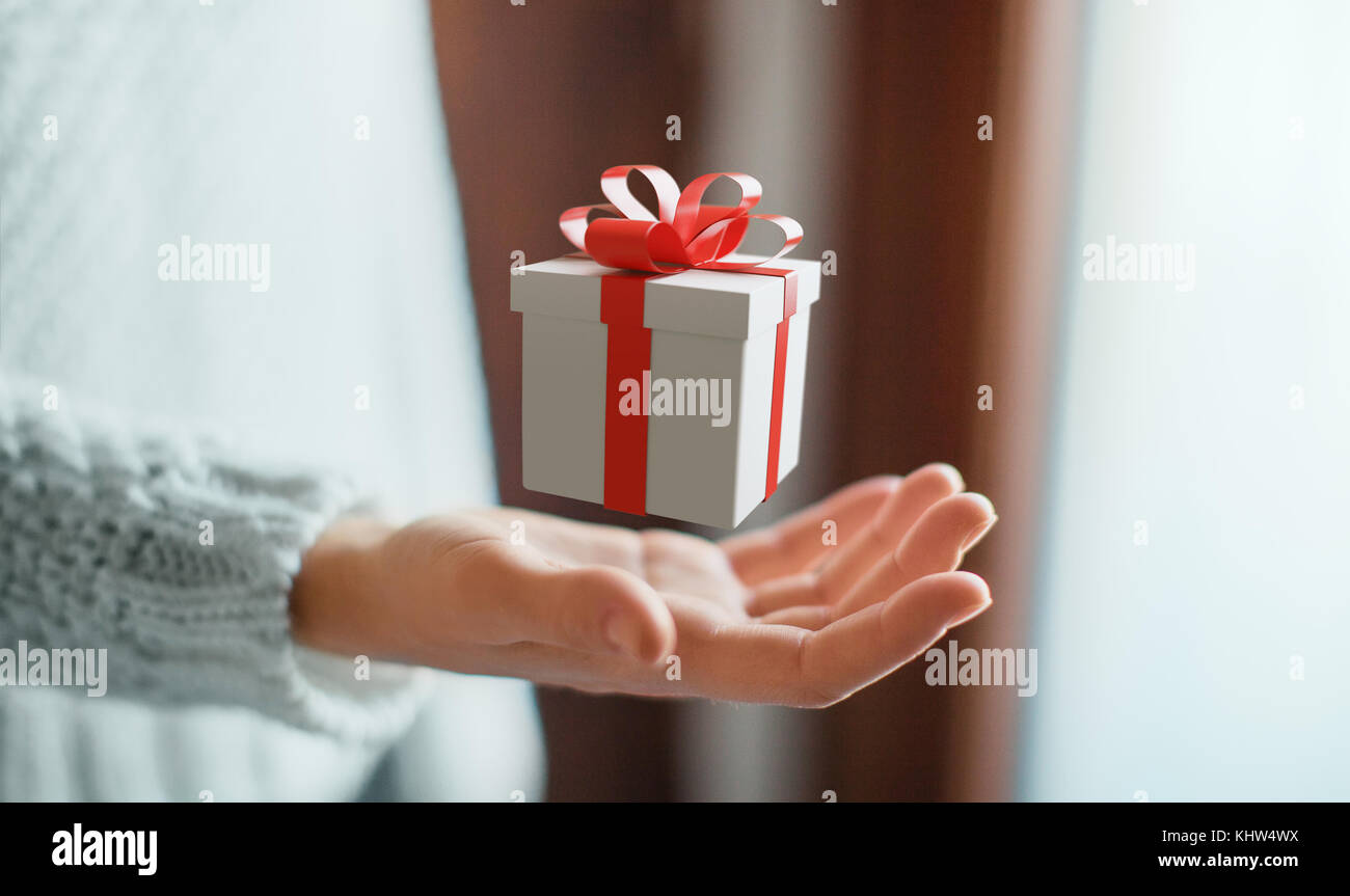 Les mains avec boîte-cadeau avec ruban rouge pour Noël Banque D'Images