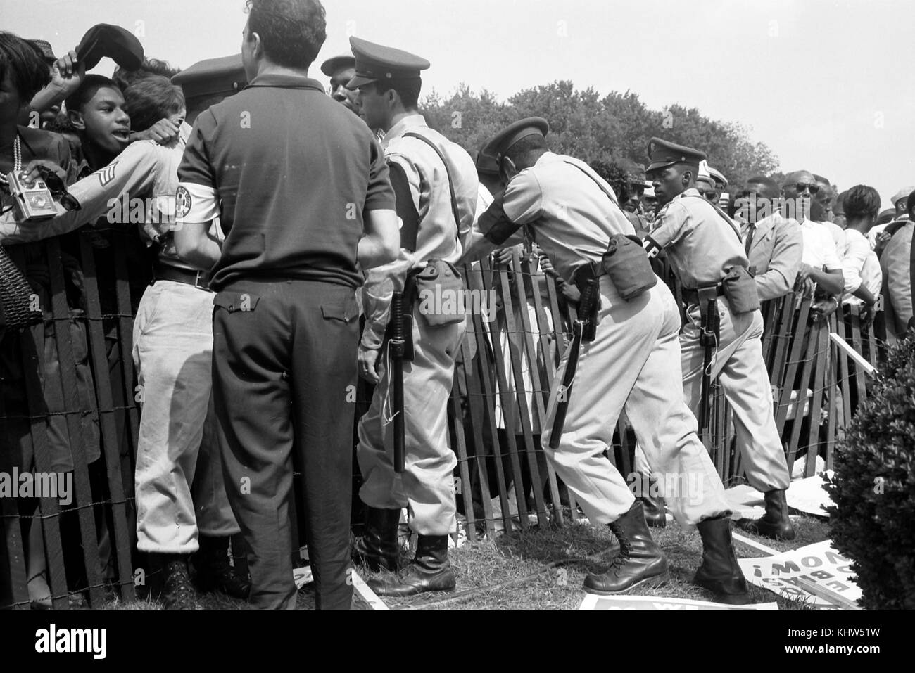 Photographie prise lors d'une manifestation à Washington, une foule d'Afro-Américains derrière une clôture de tempête avec la police de l'autre côté. En date du 20e siècle Banque D'Images