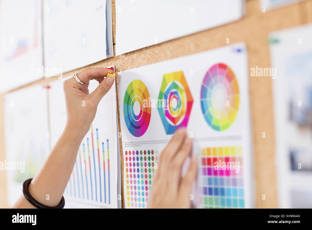 Woman pinning tableaux et graphiques en couleur Banque D'Images