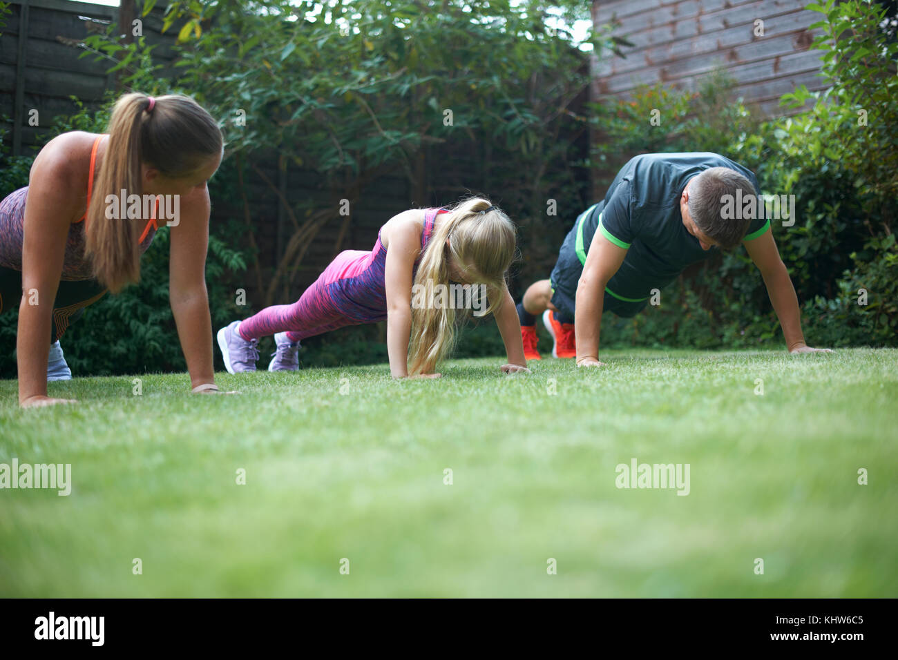 Dans l'exercice de la famille jardin, faisant push-ups Banque D'Images