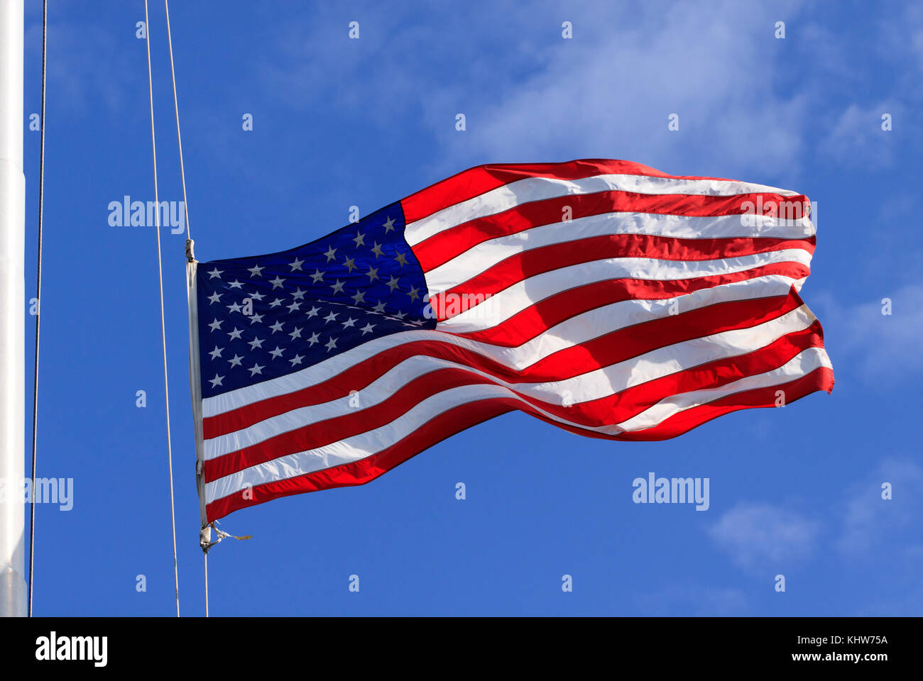 Un drapeau américain, les étoiles et les bandes, illuminé et soufflant plein dans le vent d'un mât ou mât de drapeau Banque D'Images