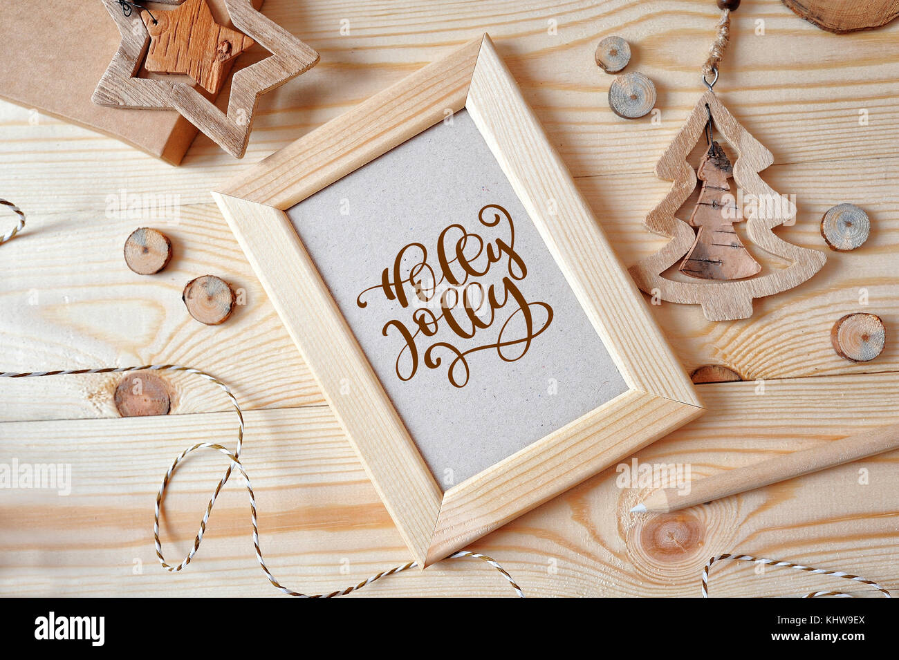 Texte noël holly jolly arrière-plan avec un cadre en bois et une étoile et un sapin de Noël. télévision lay, haut voir photo immersive Banque D'Images