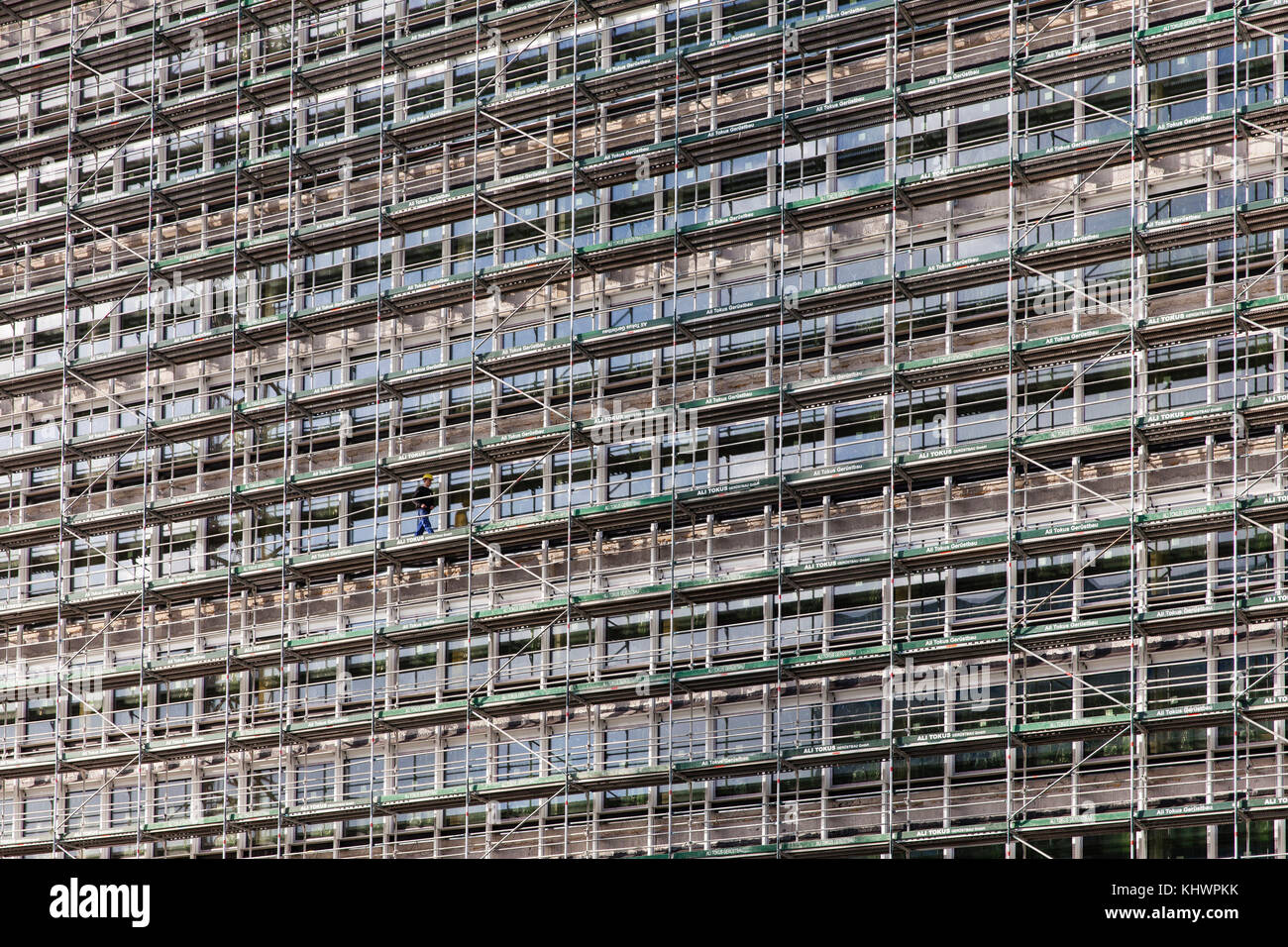 Allemagne, Cologne, un immeuble de bureaux à échafaudage dans la rue Venloer, un ouvrier solitaire. Deutschland, Koeln, Baugeruest an einem Buerohochhaus an der V. Banque D'Images