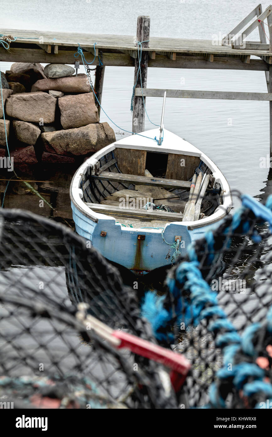 Meubles anciens en bois scandinave bateau pêcheur ligne liés à un pont de bois flotté rustique avec des fondations en pierre de granit dans l'océan de sel avec cage à homard Banque D'Images