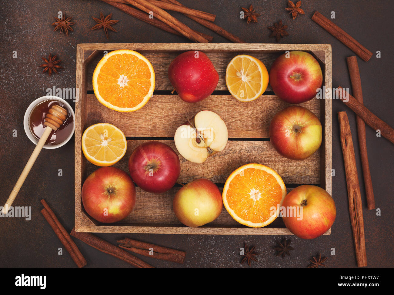 Ingrédients pour boissons d'hiver (vin chaud, punch, thé) : pommes, oranges, citrons et d'épices sur un fond sombre. Vue de dessus. Banque D'Images