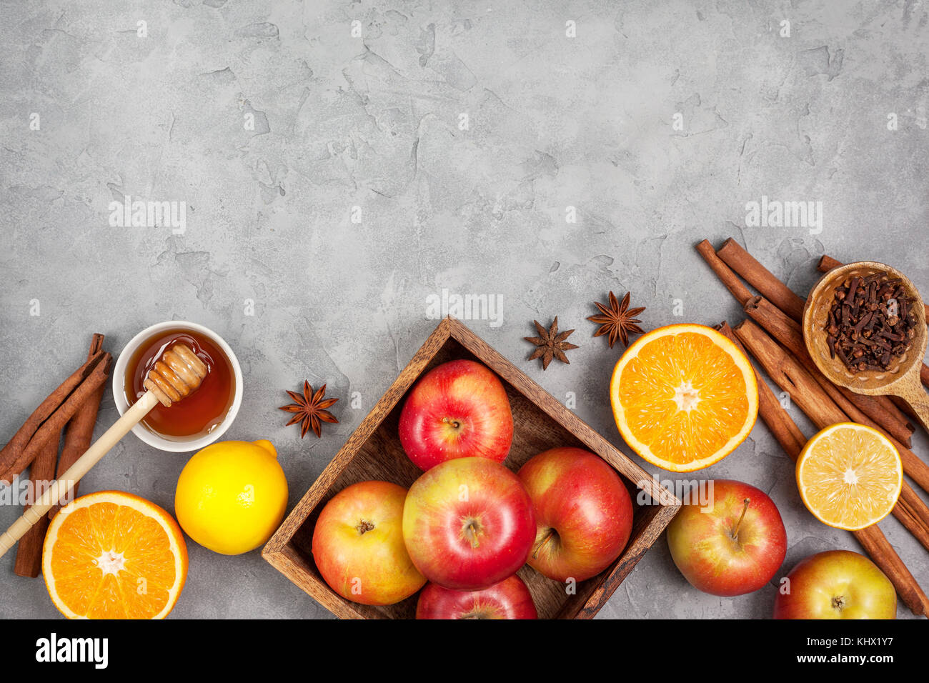 Ingrédients pour boissons d'hiver (vin chaud, punch, thé) : pommes, oranges, citrons et d'épices sur un fond de béton gris. Vue de dessus. copy space Banque D'Images