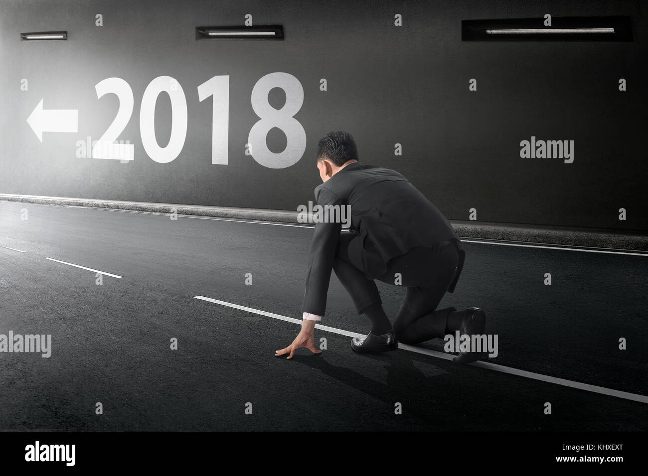 Young Asian Woman prêt à fonctionner avec le numéro 2018 sur la paroi du tunnel Banque D'Images