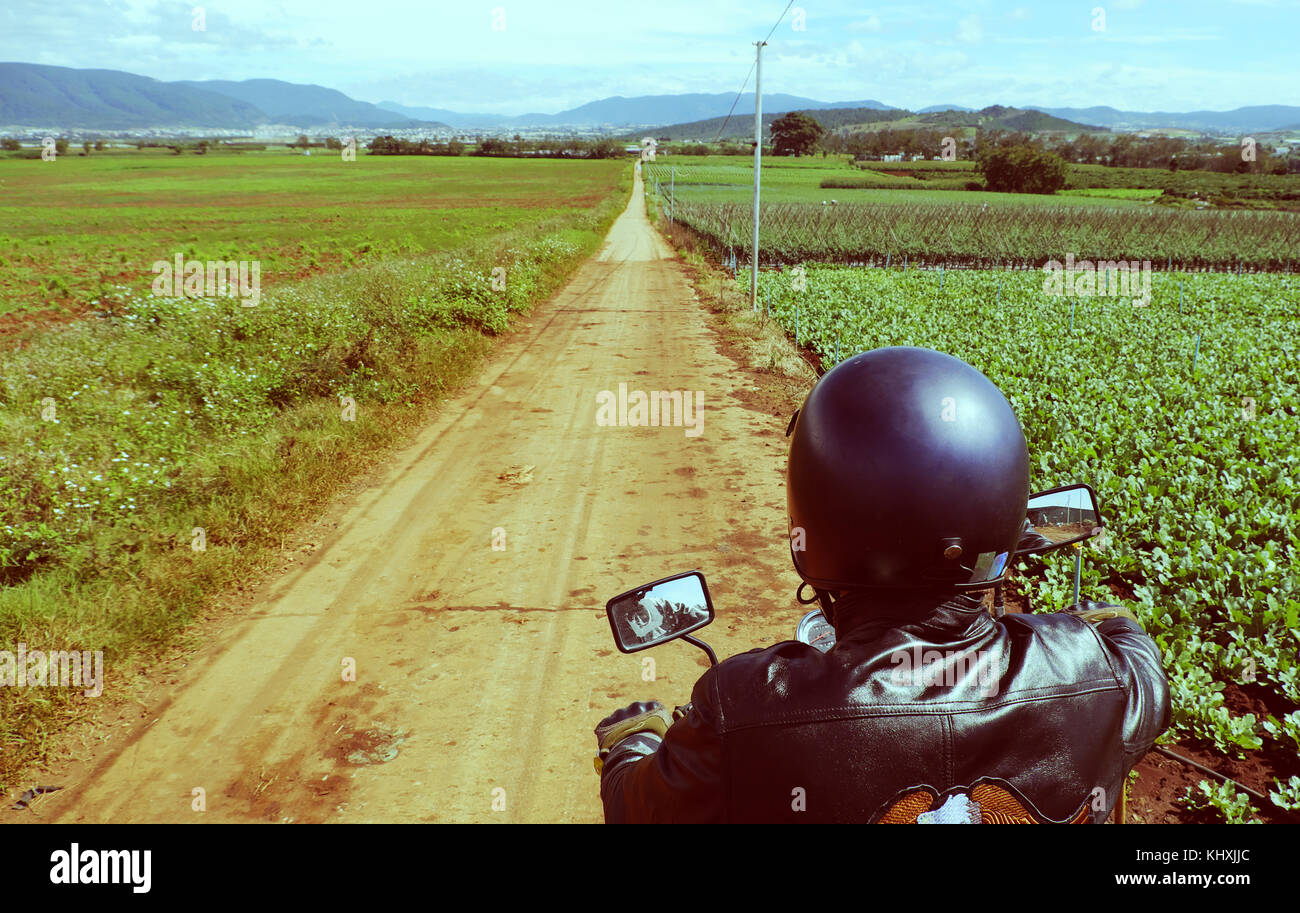 L'homme asiatique, porter un casque de moto ride sur route de campagne vietnamienne, long chemin en backpacker voyage aventure Banque D'Images