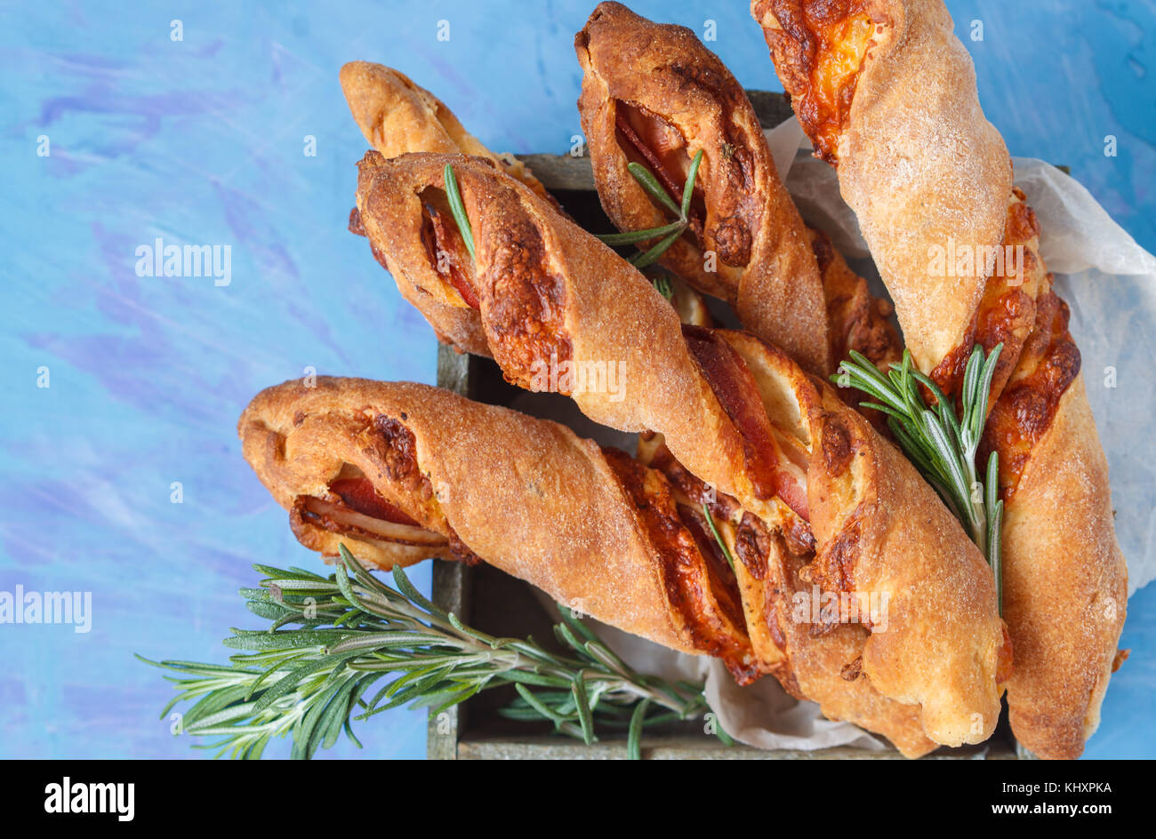Bâtonnets de fromage savoureux avec du bacon, les herbes en boîte en bois. vue d'en haut, sur fond bleu. viande  + fromage snack pour la bière, le concept de parti, jour de Thanksgiving. Banque D'Images