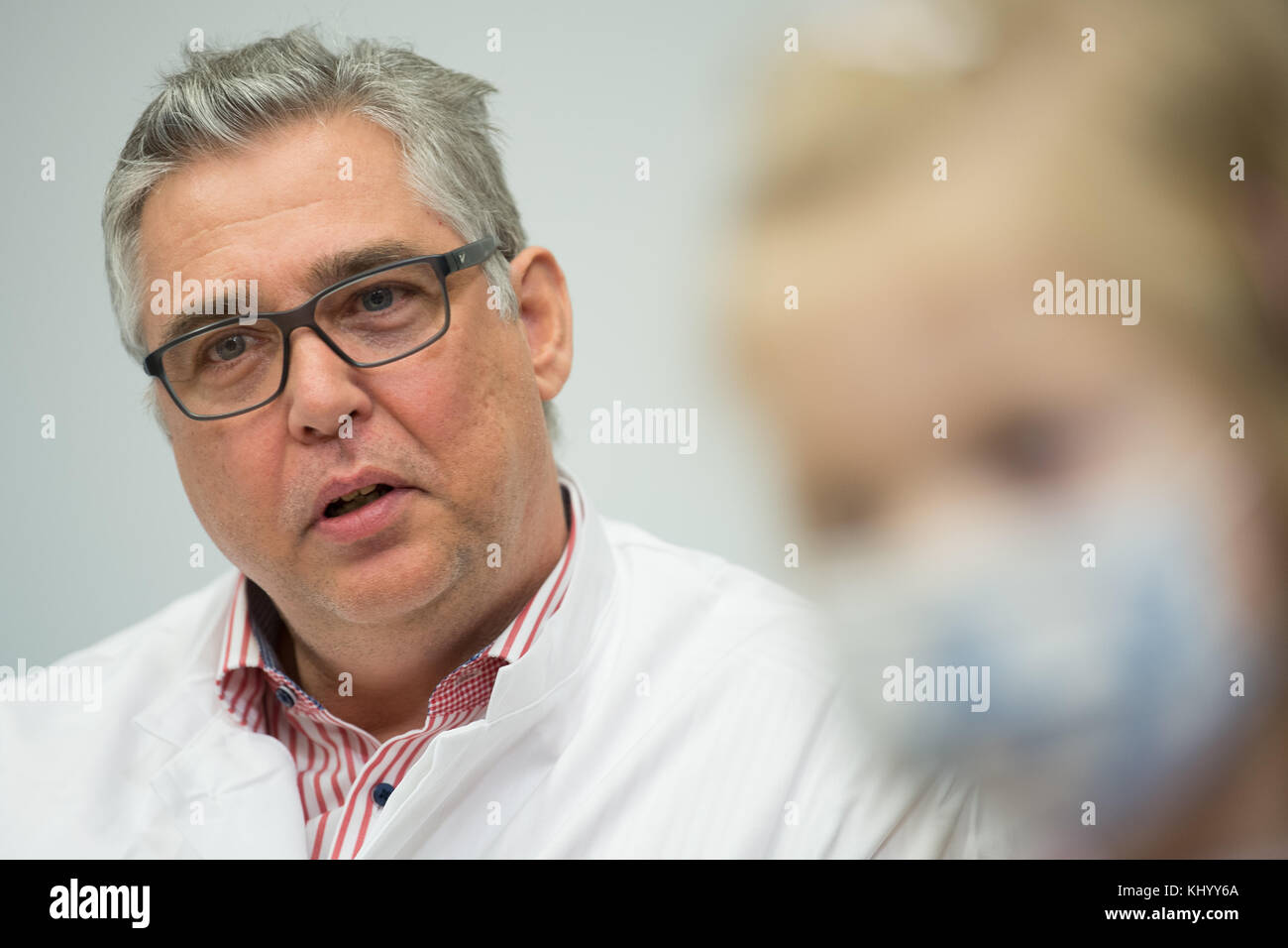 Hanovre, Allemagne, 22 novembre 2017Alexander Horke, chef du service de chirurgie des malformations cardiaques congénitales à l'hôpital pour enfants de la MHH, parle pendant que Nina est assise à côté de lui lors d'une conférence de presse à l'École de médecine de Hanovre (MHH), Allemagne, le 22 novembre 2017. Nina, quatre ans, est née avec une grave anomalie cardiaque. Maintenant, elle a eu une greffe cardiaque. Photo : Swen Pförtner/dpa Banque D'Images