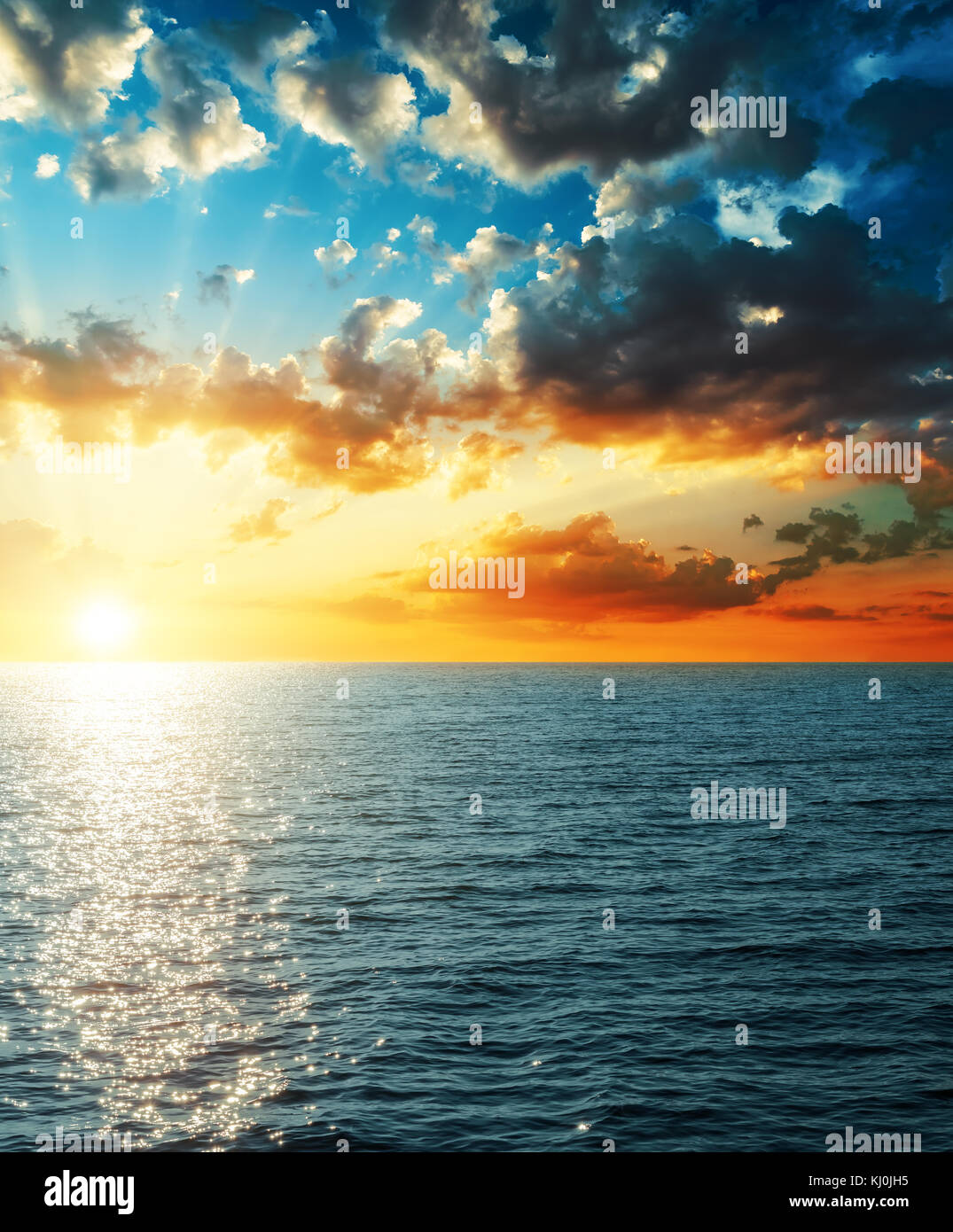 Coucher du soleil brillant dans les nuages au-dessus de la mer Banque D'Images