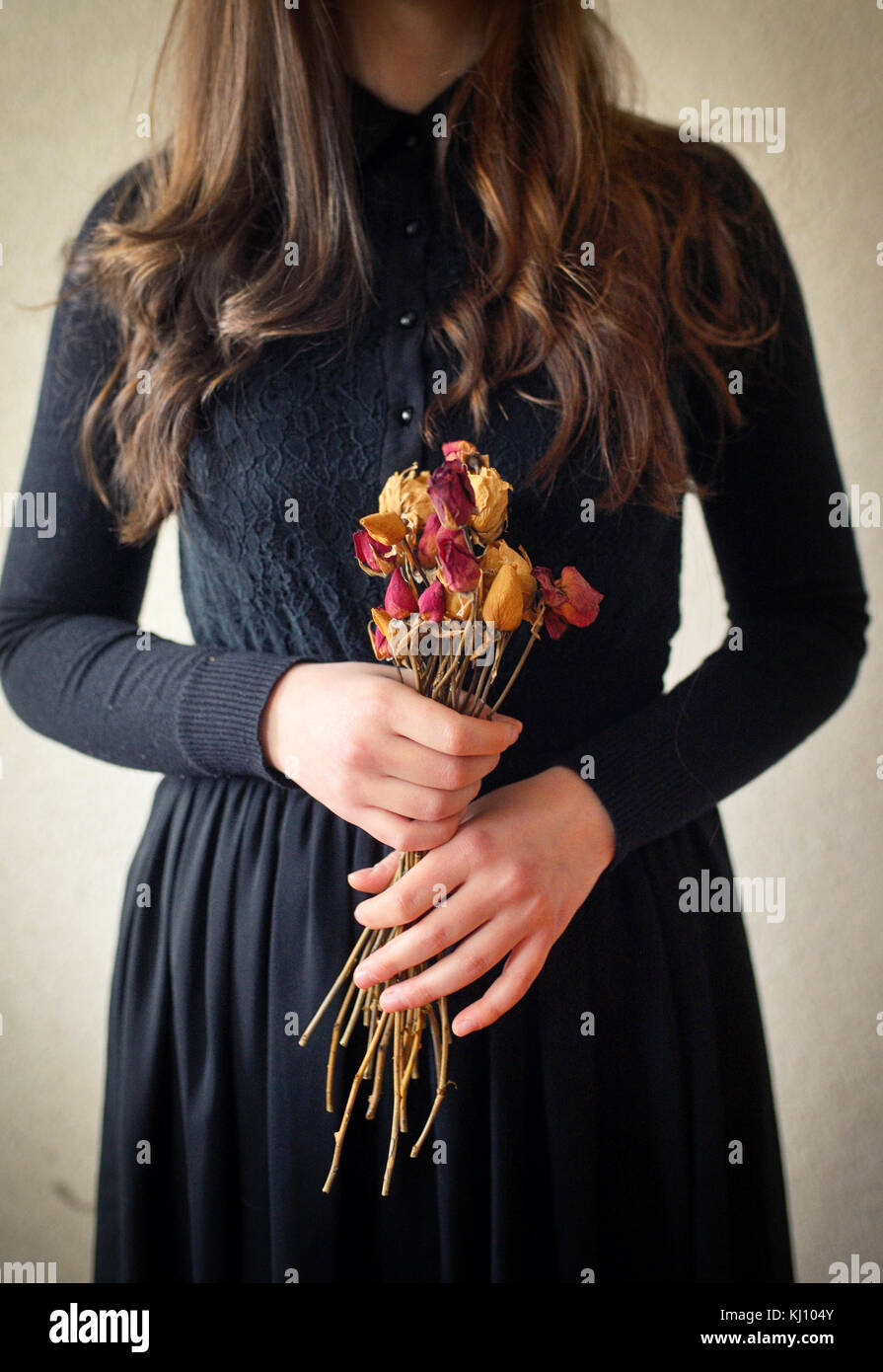 Jeune fille en robe vintage noire et fleurs séchées Banque D'Images