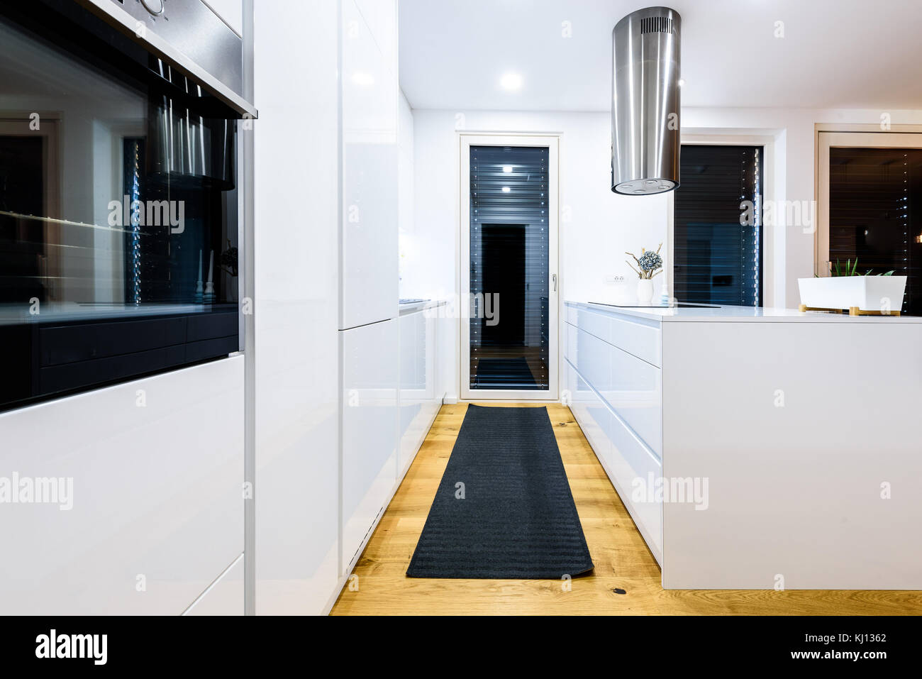 Nouveau design intérieur blanc moderne équipée avec appareils de cuisine. résidence cuisine avec évier, cuisinière, plaque de cuisson et placards en bois blanc et dur Banque D'Images