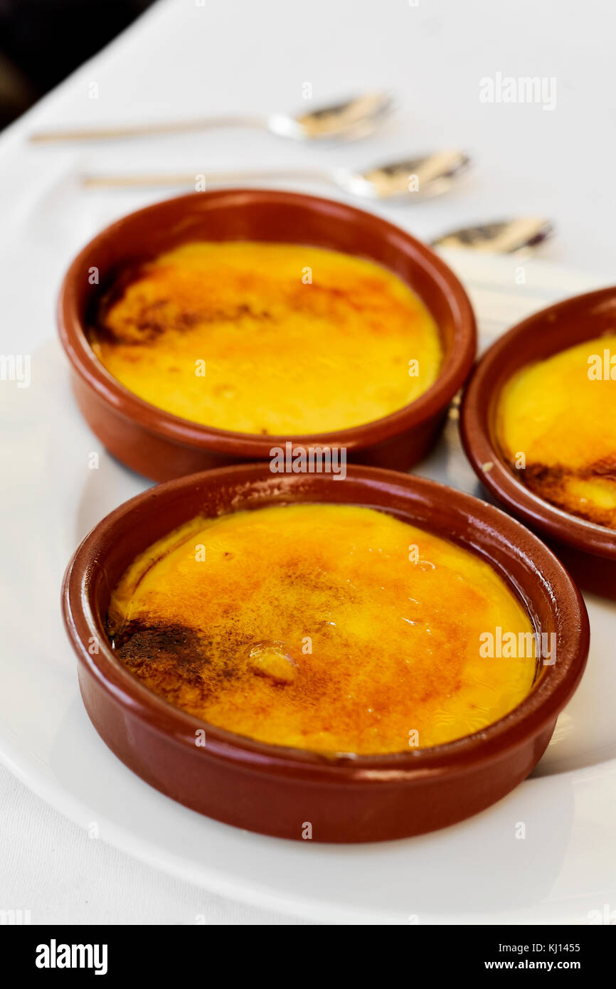 Quelques bols en faïence avec crème catalana, crème brûlée typique de Catalogne, Espagne, sur une table Banque D'Images