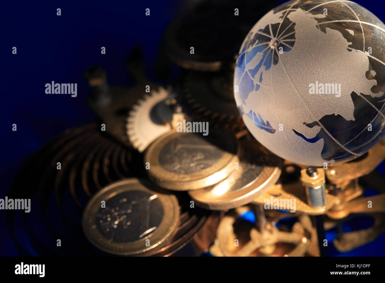 Globe en verre posé sur les pignons et de pièces sur fond bleu foncé Banque D'Images
