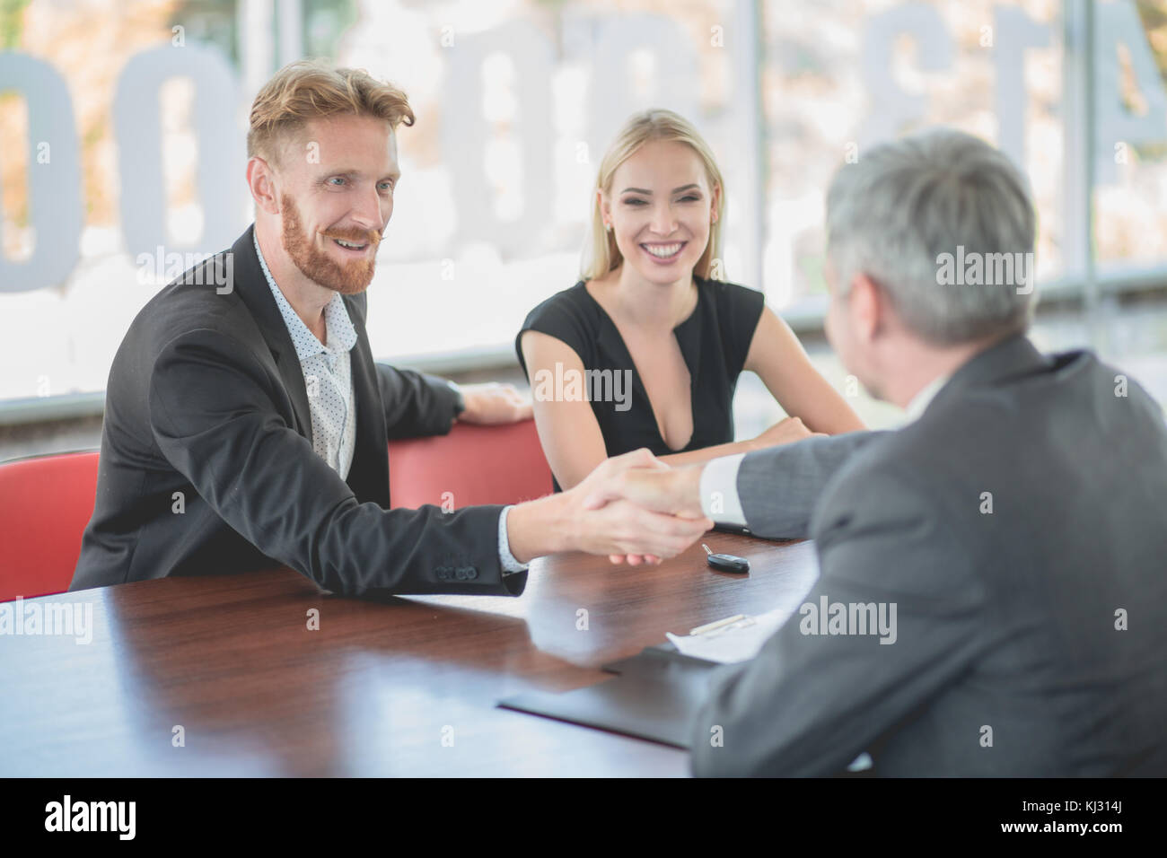 Happy young couple achat nouvelle voiture, la signature des documents avec le concessionnaire. Banque D'Images