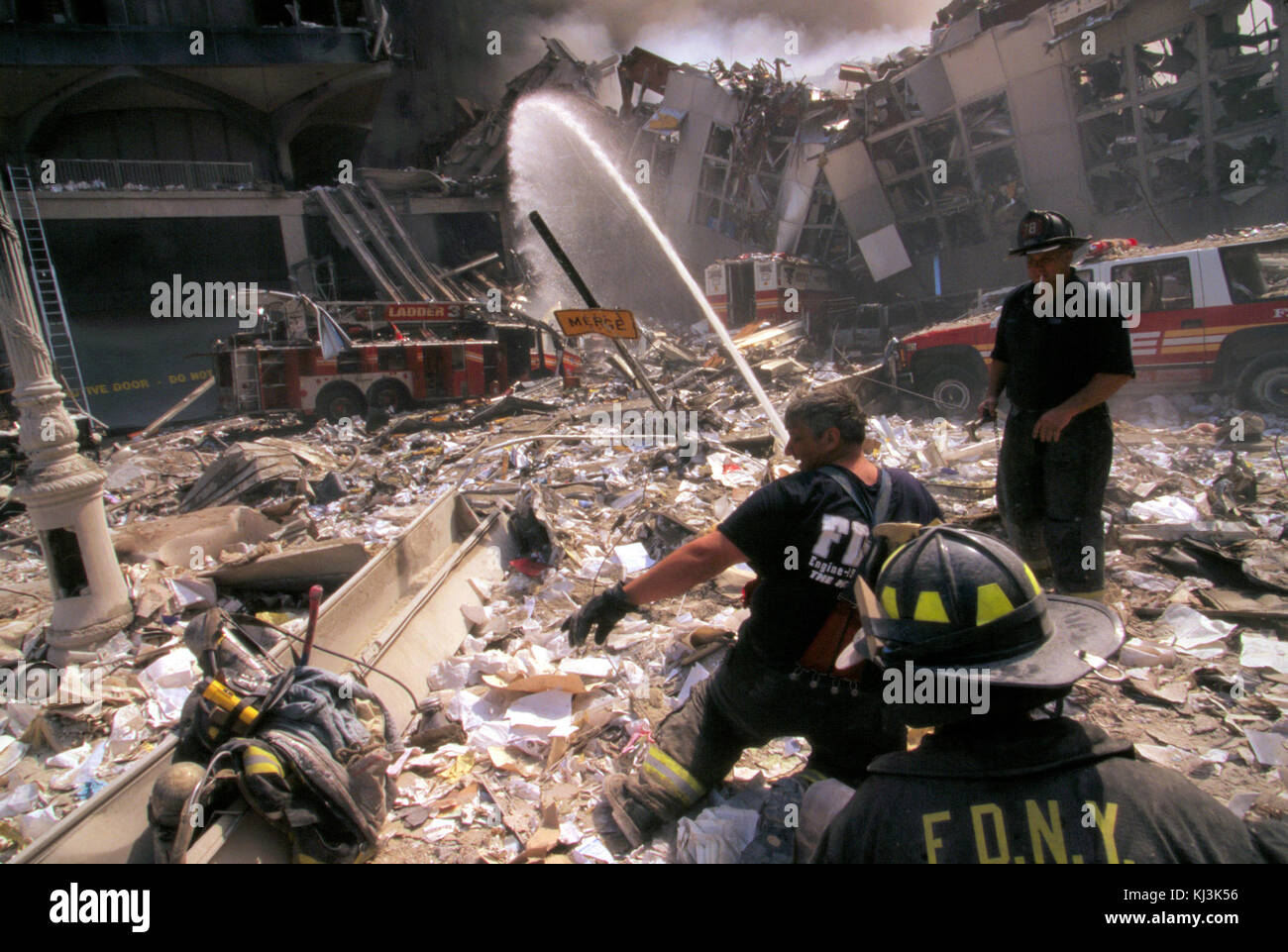 Trois pompiers de New York pulvérisent de l'eau sur des ruines couvantes à la suite de l'attaque terroriste du 11 septembre Banque D'Images