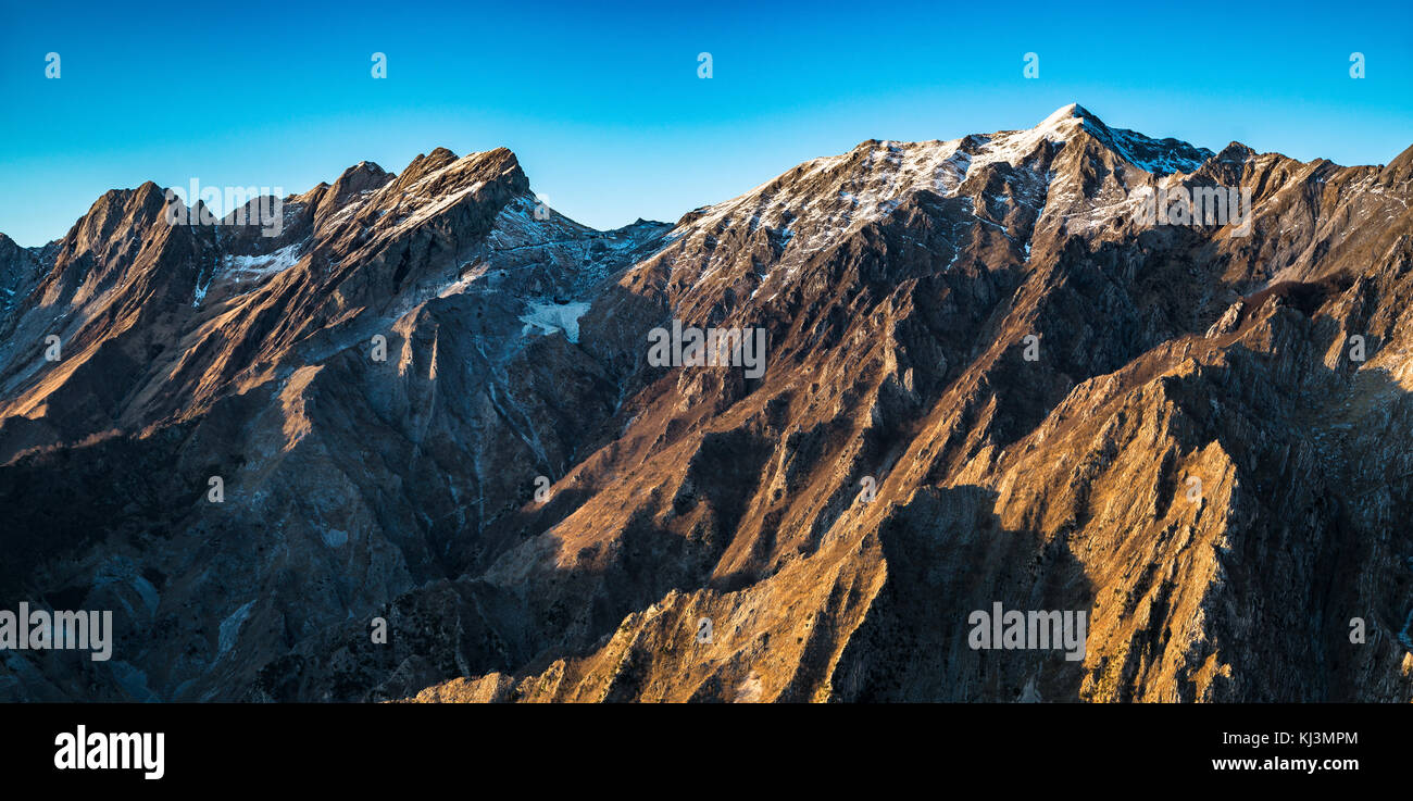 Alpi Apuane ou les montagnes enneigées des Alpes Apuanes et la carrière de marbre au coucher du soleil en hiver. Carrara, toscane, italie. Banque D'Images