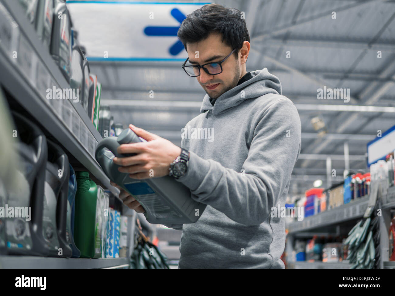 Smart client qui achète de l'huile de lubrification du moteur dans la voiture supermarché Banque D'Images