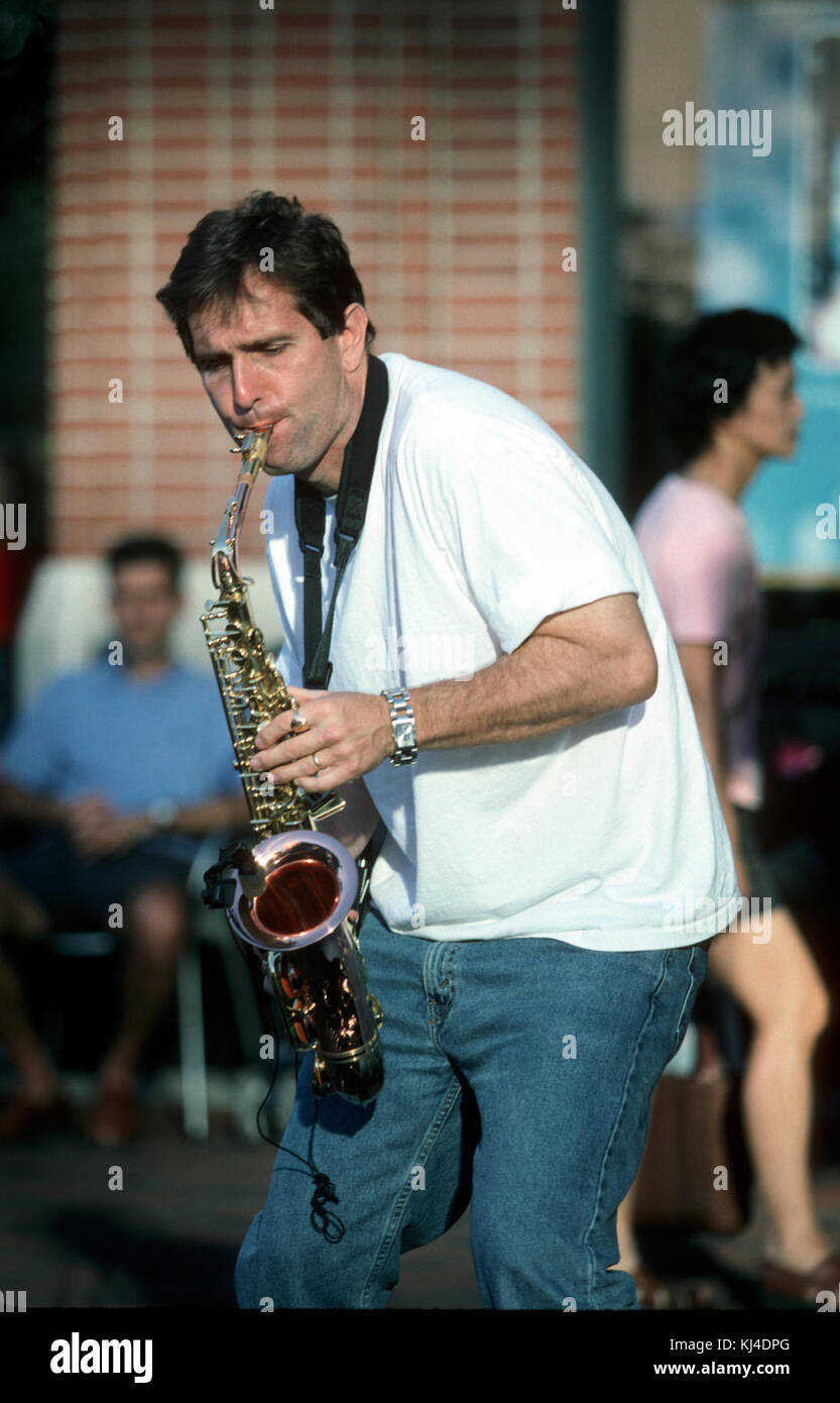 Un homme est représenté jouant du saxophone, un instrument emblématique connu pour son utilisation dans le jazz et la musique classique, souvent associé à des performances expressives et émouvantes. Banque D'Images