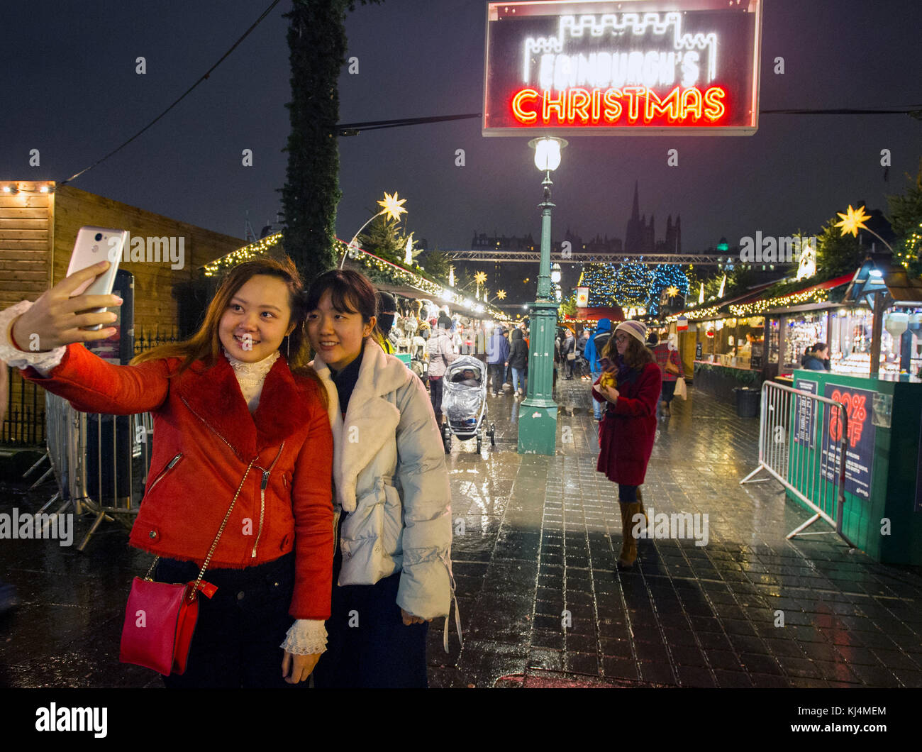 Deux touristes prendre un en dehors de la selfies Marché de Noël d'Édimbourg sur Princes Street d'Édimbourg. Banque D'Images