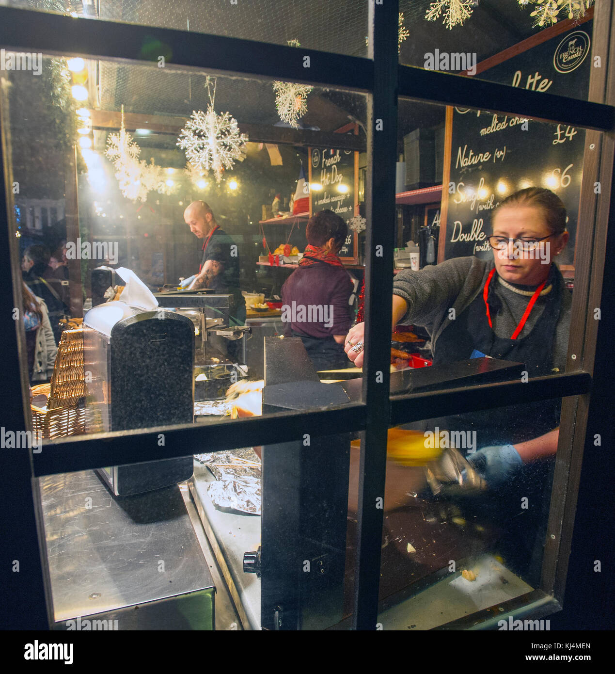 Les détenteurs de décrochage préparer repas de fête au marché de Noël d'Édimbourg sur la butte, Édimbourg. Banque D'Images