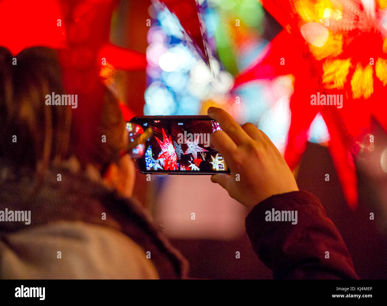 Un touriste prend une photo de lanternes de Noël à un décrochage dans le marché de Noël d'Édimbourg. Banque D'Images