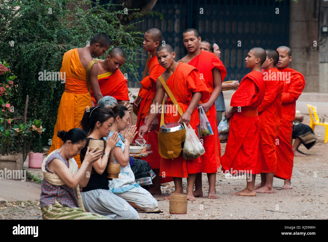 Les moines reçoivent l'aumône chaque matin les femmes de l'endroit, qui sont ainsi 'make mérite' pour eux-mêmes. Pakse, Laos Banque D'Images