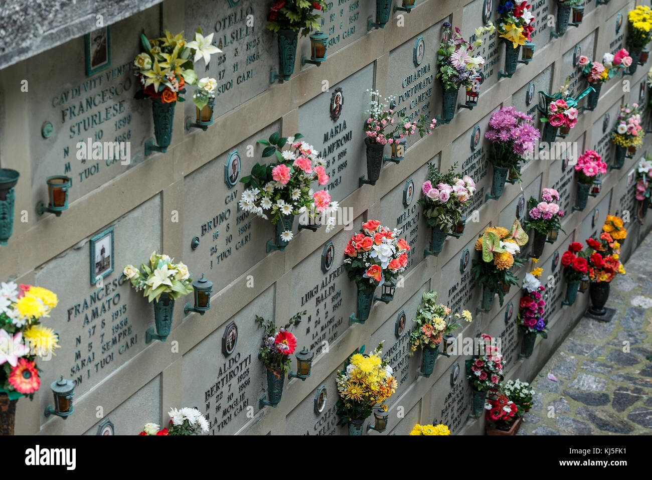Des fleurs ornent les caveaux funéraires du cimetière du village, Porto Venere, Italie. Banque D'Images