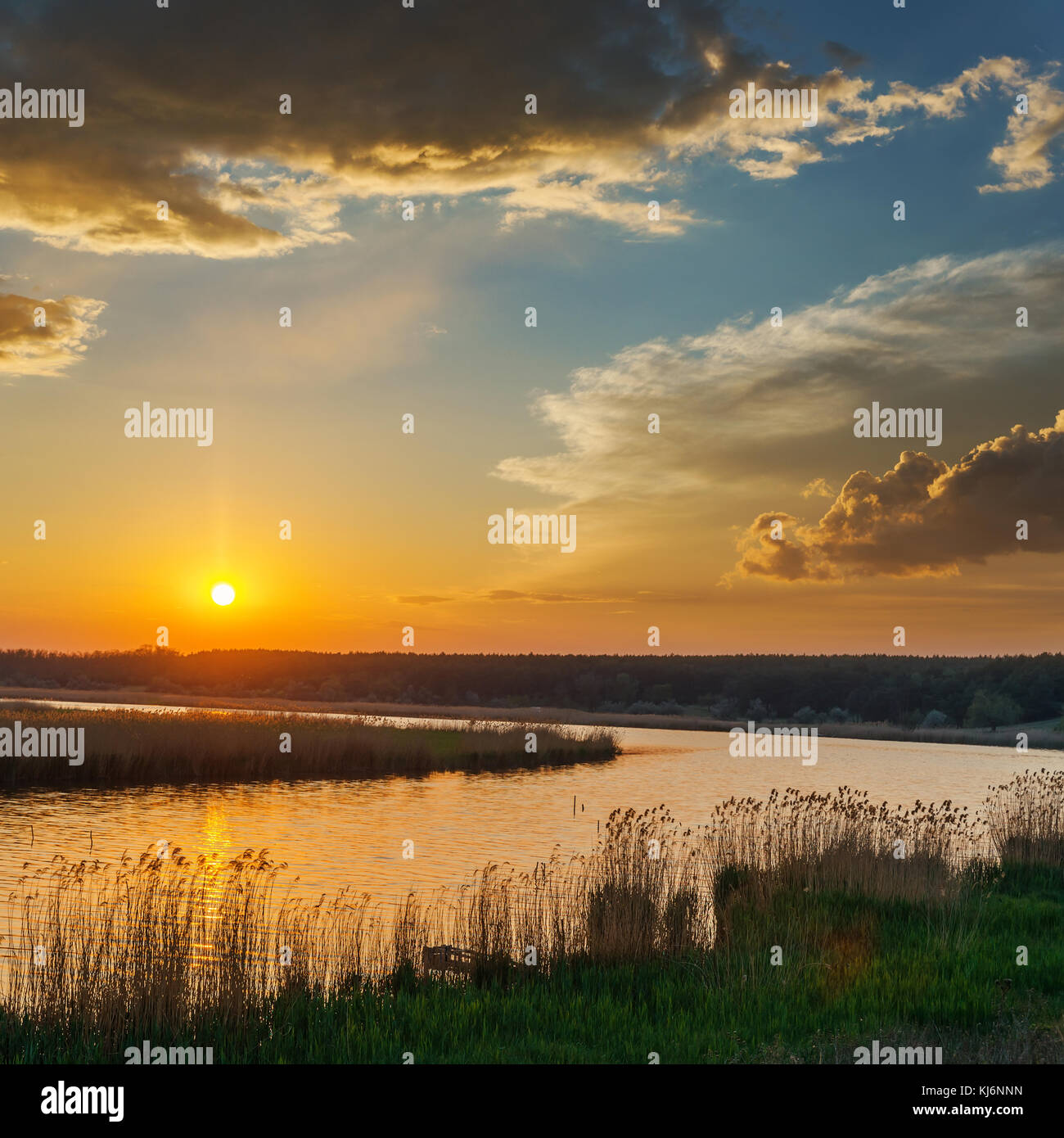 Au coucher du soleil Ciel dramatique sur la rivière Banque D'Images