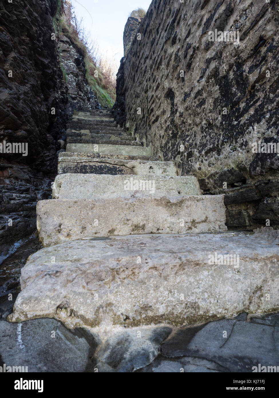 Marches de pierre couper à travers un mur raide jusqu'à partir de la plage, balayées par le vent, menant de Waterwynch Beach sur une journée en hiver le Parc National du Pembrokeshire, Pays de Galles Banque D'Images