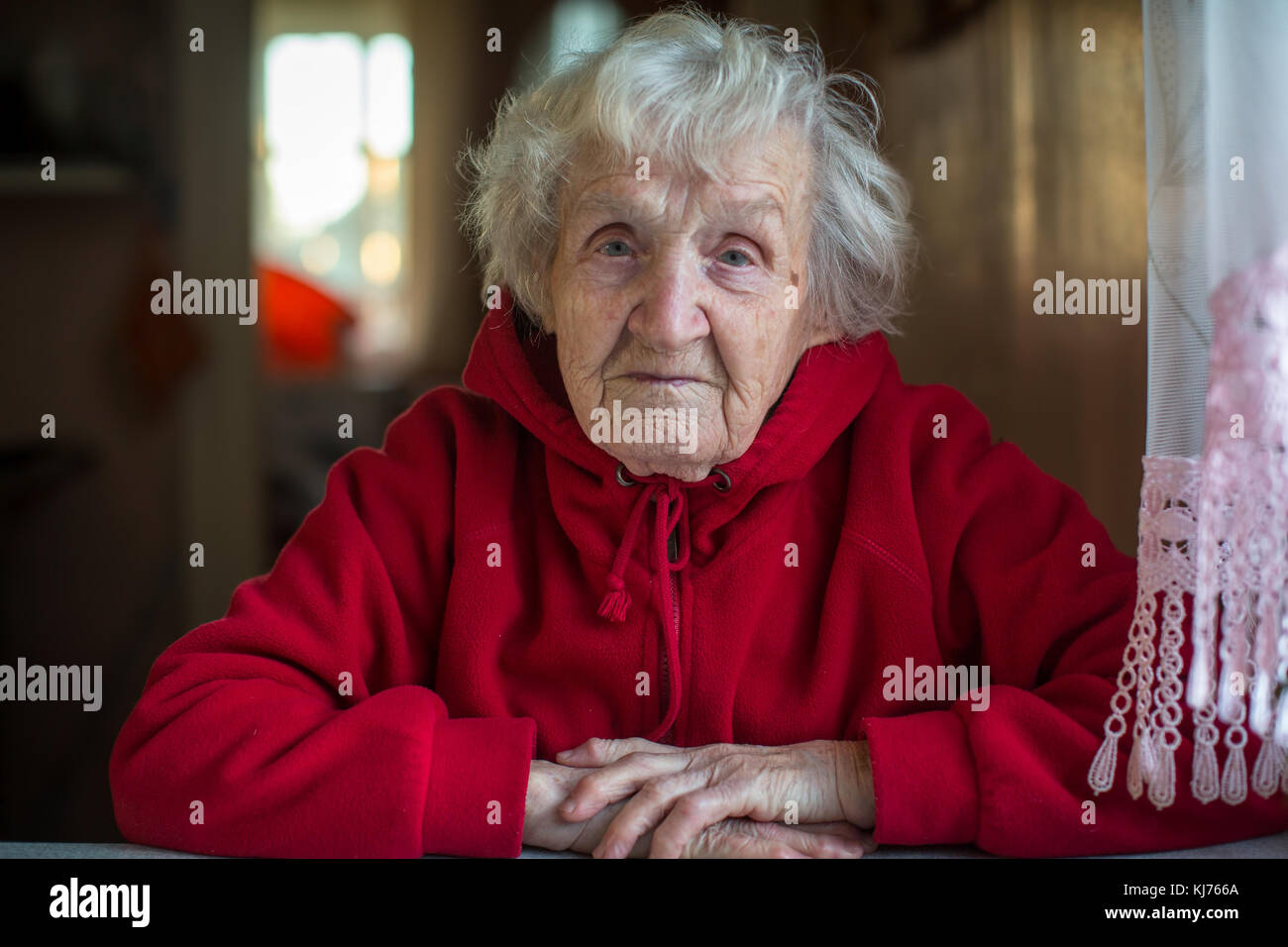 Portrait de femme âgée dans une veste rouge vif. Banque D'Images